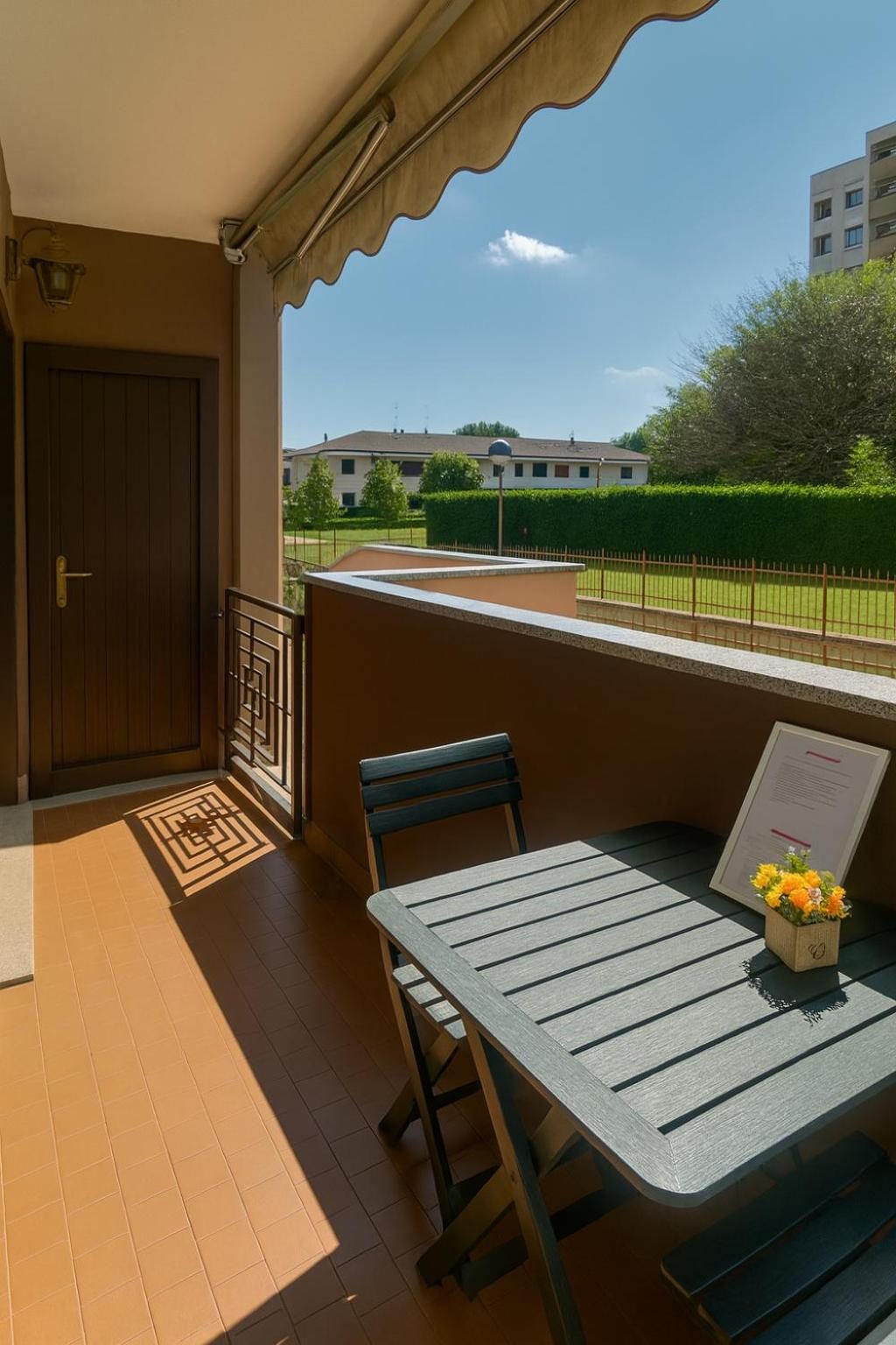 The balcony with a small table, looking onto the greenery