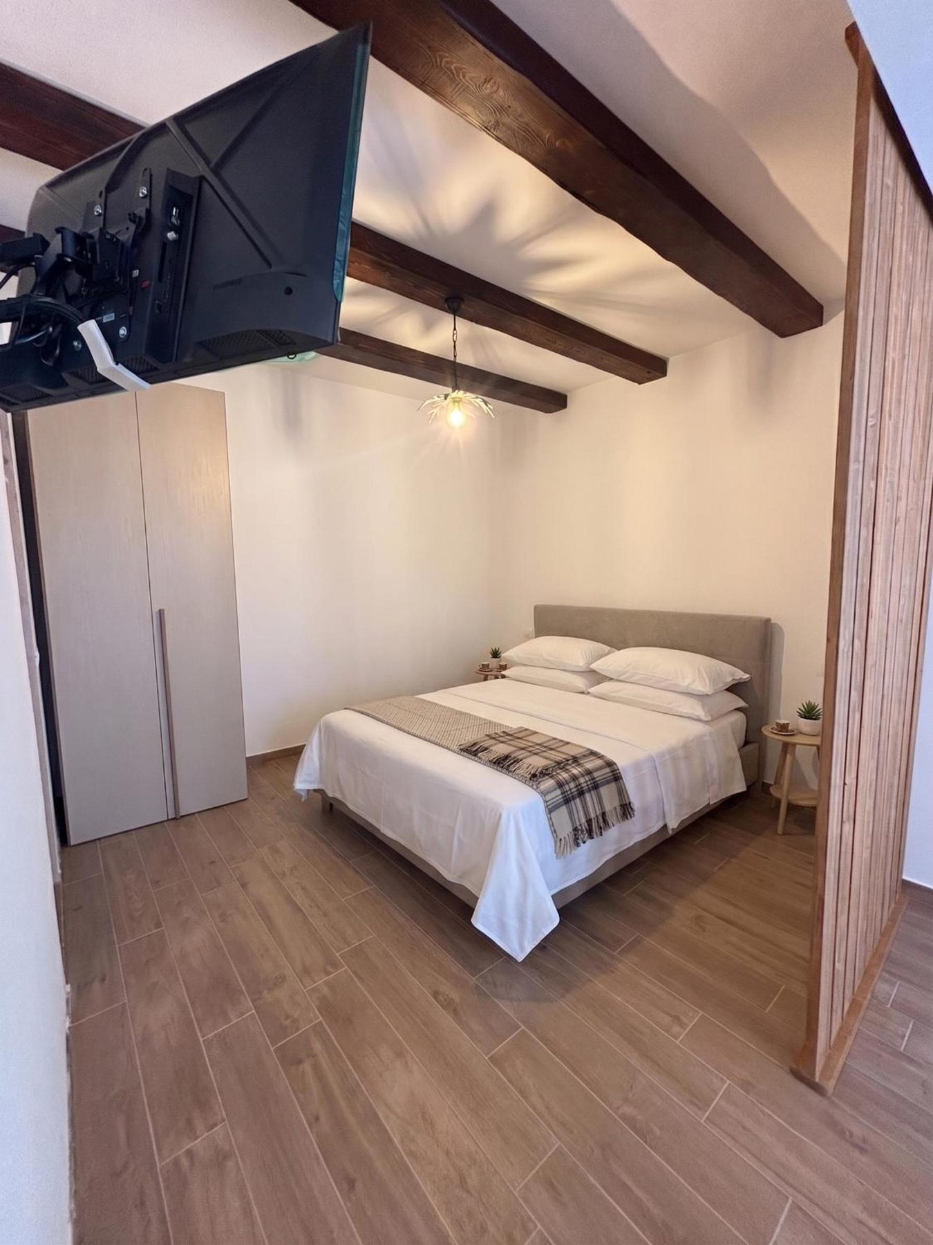The bedroom seen from the door, with the wardrobe and the TV