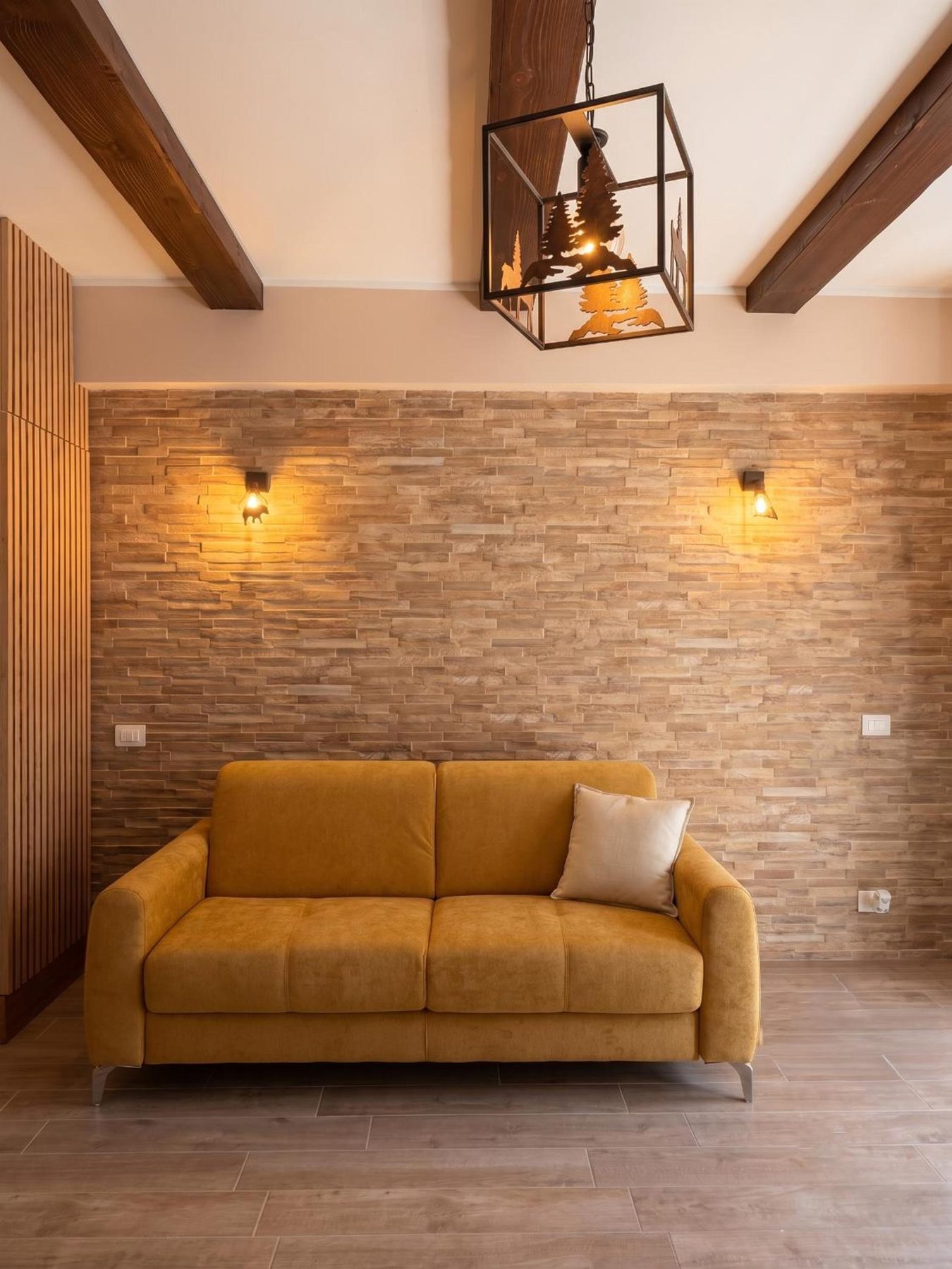 The mustard sofa against the stone wall