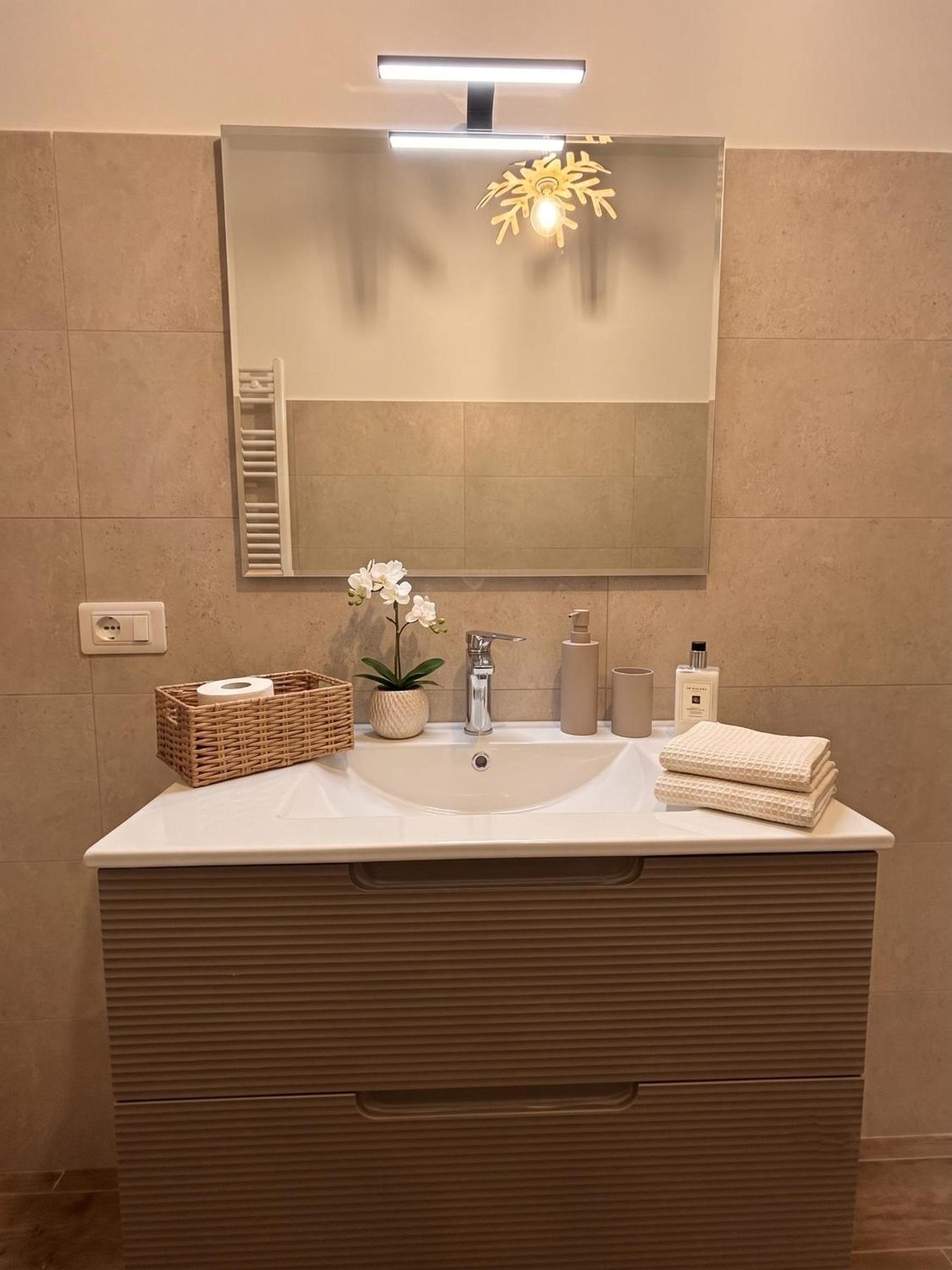 The bathroom basin, with mirror and fresh towels