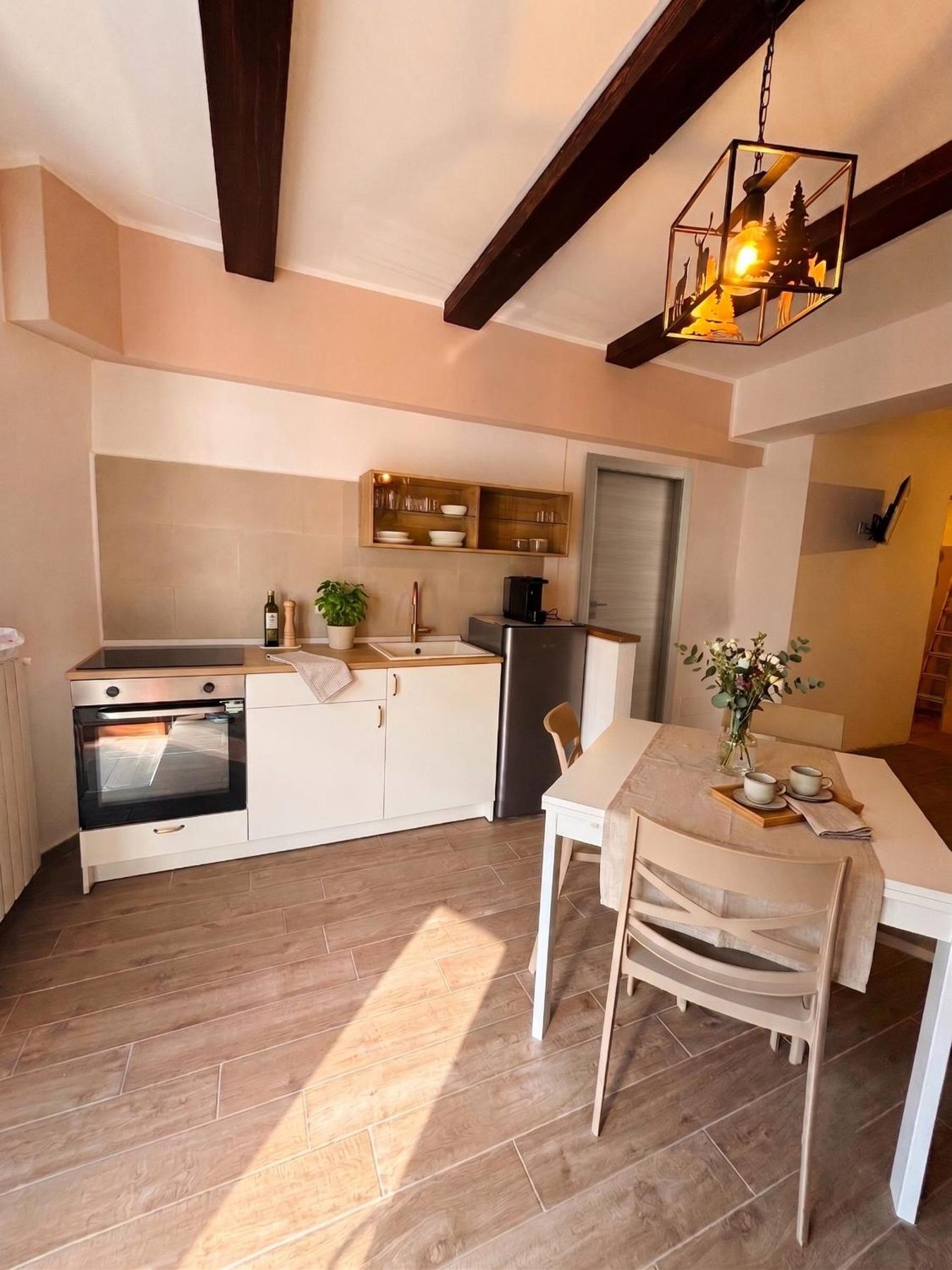 La Rua's living area: kitchen, table and sunlight on the wooden floor