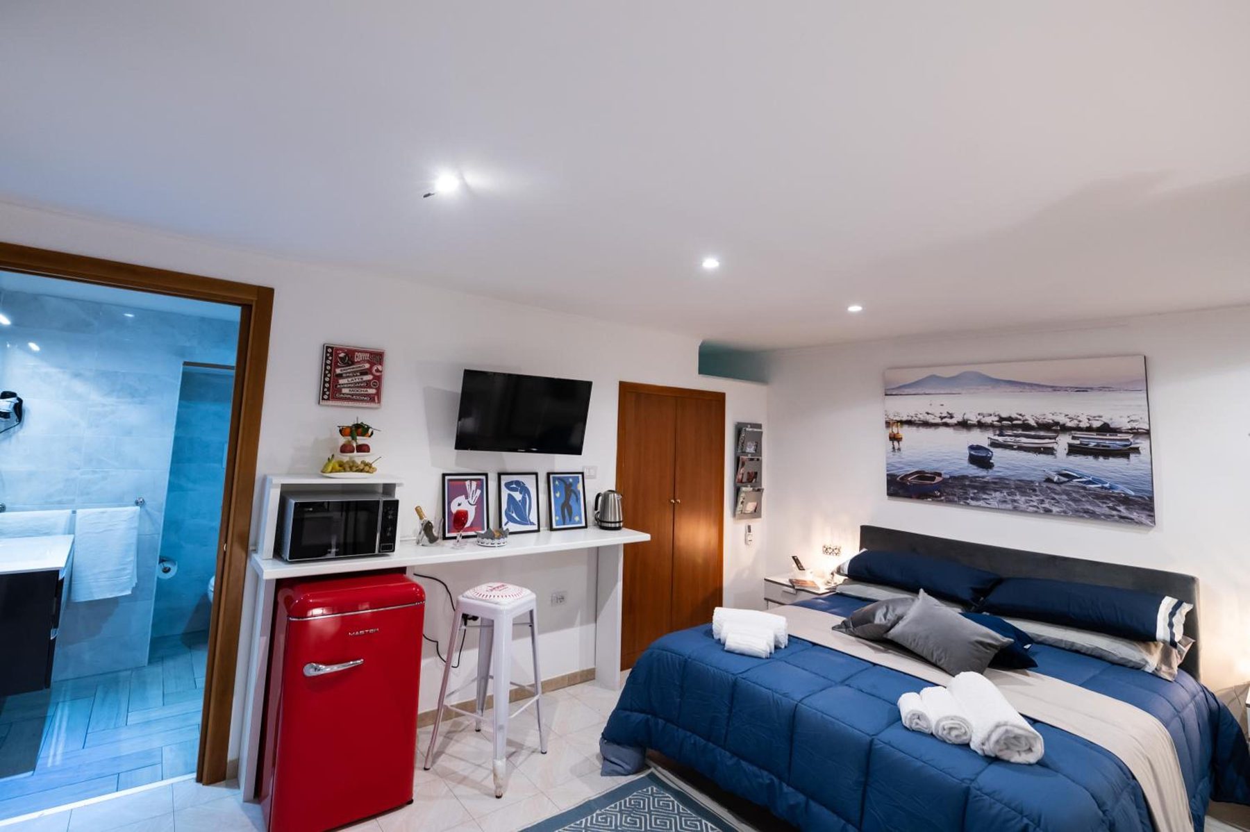 The corner with the red fridge, the kettle and the bathroom on the right